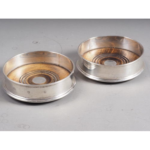 291 - A pair of silver bottle coasters with turned bases