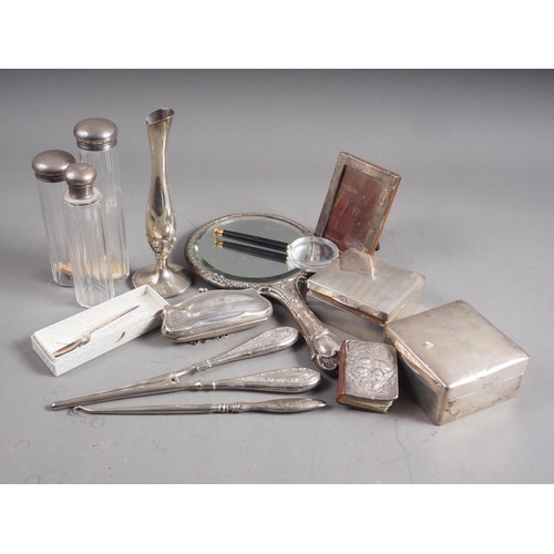 301 - A silver backed dressing table mirror, two silver cigarette boxes, three dressing table jars, a spoo... 