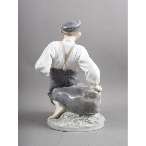 6 - A circa 1960s Royal Copenhagen figure of a shepherd boy sitting on a rock, 12 1/2