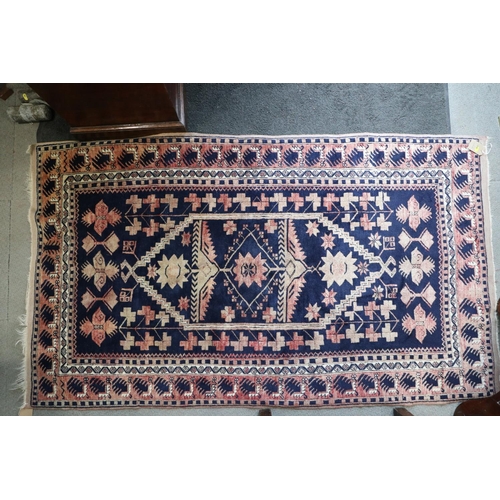 644 - A Caucasian tribal rug with stylised floral centre on a blue ground and multi-bordered in shades of ... 