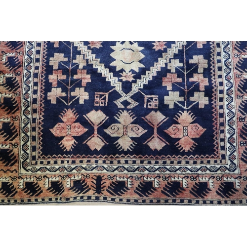 644 - A Caucasian tribal rug with stylised floral centre on a blue ground and multi-bordered in shades of ... 