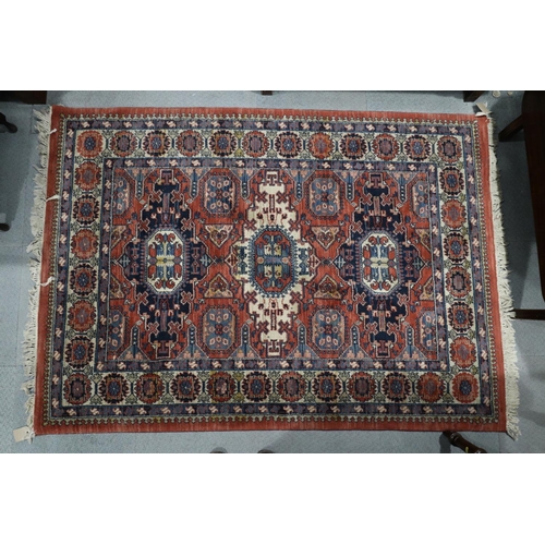 651 - A Louis de Poortere rug of traditional Persian design with geometric design in shades of red, blue, ... 