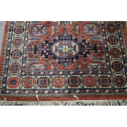 651 - A Louis de Poortere rug of traditional Persian design with geometric design in shades of red, blue, ... 