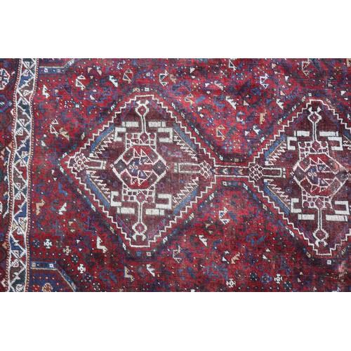 649 - A Qashqui rug with four medallions, on a red animal and bird figured ground with multi-borders, in s... 