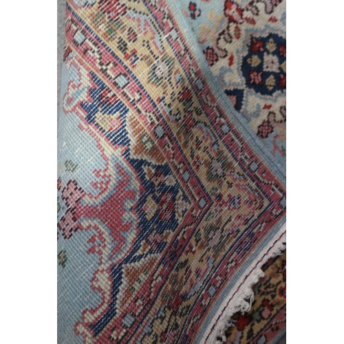 648 - A Persian rug of traditional design with central medallion on a turquoise blue ground and bordered i... 