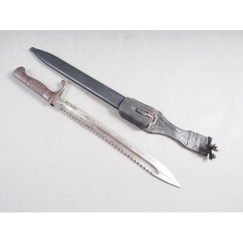 179 - A German WWI butcher's sawback bayonet, in metal scabbard with frog and leather holder , 20 1/2