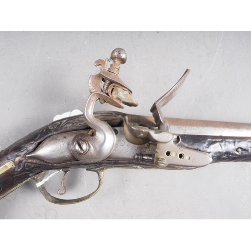 190 - A Continental flintlock long barrel pistol with carved and inlaid stock, 19