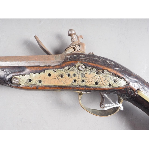 190 - A Continental flintlock long barrel pistol with carved and inlaid stock, 19