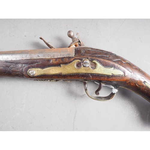 196 - A Continental flintlock pistol with carved and inlaid walnut stock, 19