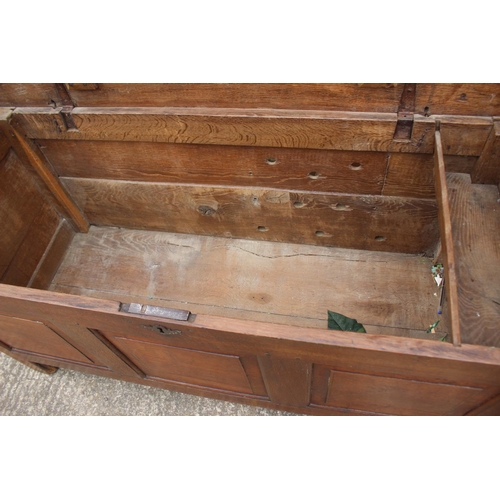 465 - An early 18th century oak triple panel front coffer with candle box, on stile supports, 52