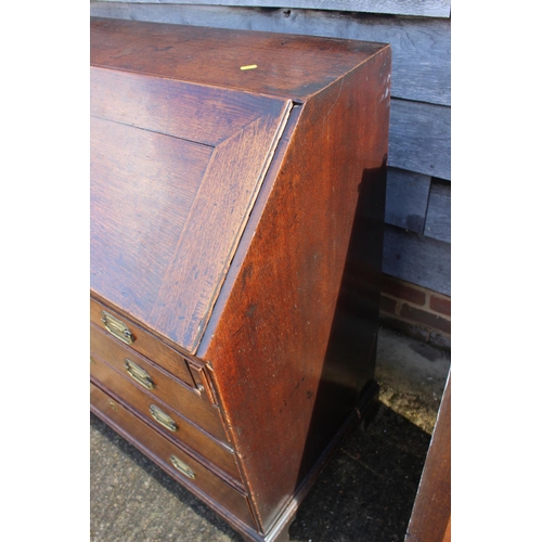 494 - A late Georgian oak fall front bureau with part fitted interior over four long graduated drawers, on... 