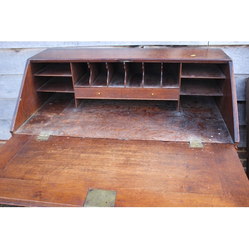 494 - A late Georgian oak fall front bureau with part fitted interior over four long graduated drawers, on... 