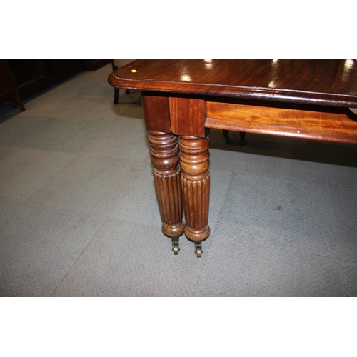 565 - An early 20th century walnut extending dining table with two extra leaves, on six reeded turned and ... 