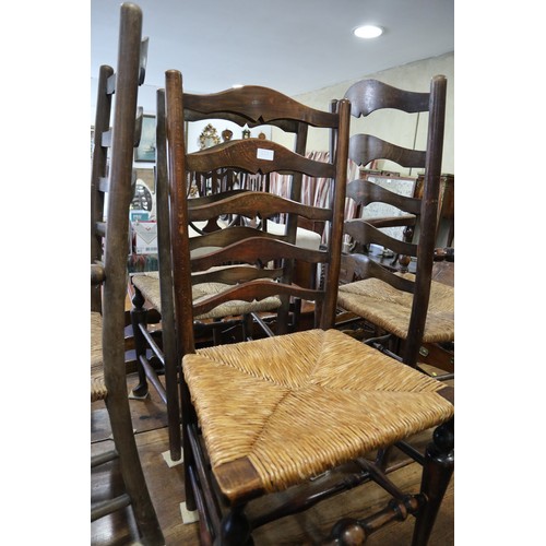 580 - A pair of ladder back carver chairs with rush envelope seats, on turned and stretchered supports, th... 