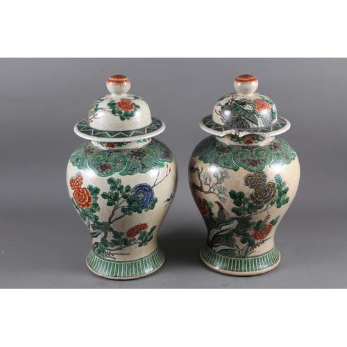 108 - A pair of Chinese famille verte crackle glazed baluster jars and covers with birds in a landscape de... 