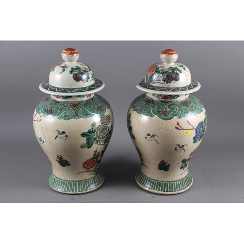 108 - A pair of Chinese famille verte crackle glazed baluster jars and covers with birds in a landscape de... 