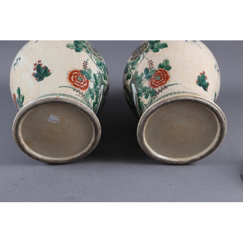 108 - A pair of Chinese famille verte crackle glazed baluster jars and covers with birds in a landscape de... 