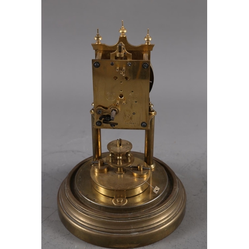 126 - A brass anniversary clock, under a glass dome shade, 12