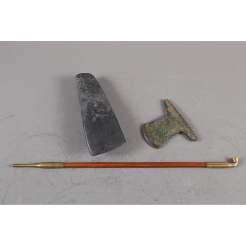 139 - A bronze axe head, a hand-held stone axe and an opium pipe