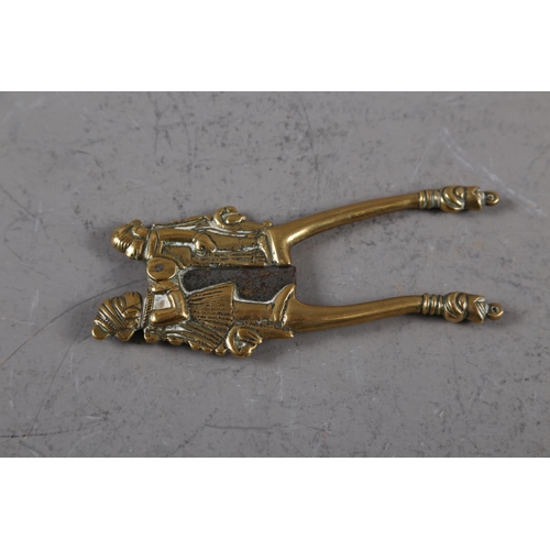 156 - An Indian brass and steel betel nut cutter with figure decoration, 5 1/2