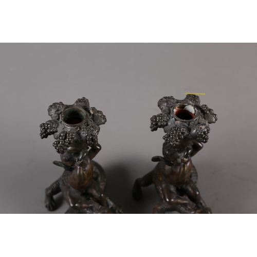 157 - A pair of 19th century bronze candlesticks, formed as putto seated on crocodiles, 8 3/4