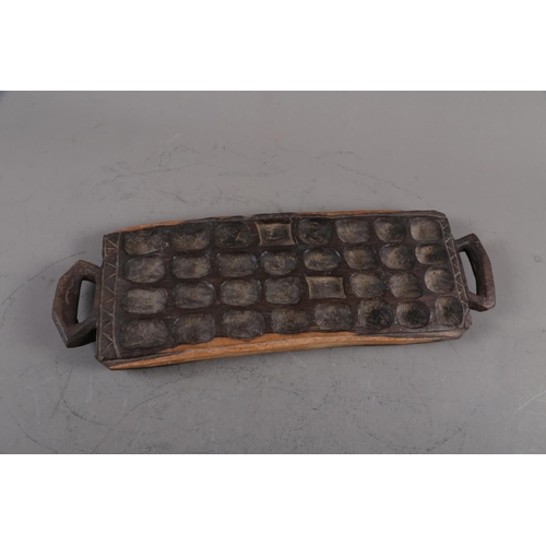 171 - An African ebony mancala board, 19 1/2