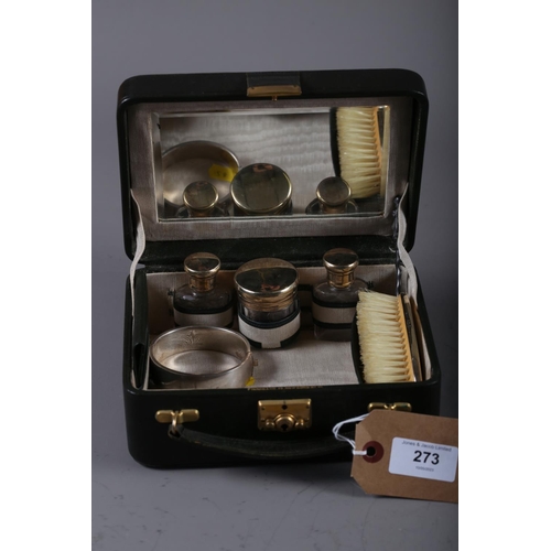 273 - A lady's green leather vanity case with silver mounted bottles, a silver hinged bangle and a set of ... 