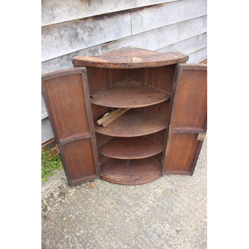 479 - An 18th century quarter-cut oak bowfront corner hanging cupboard, 23