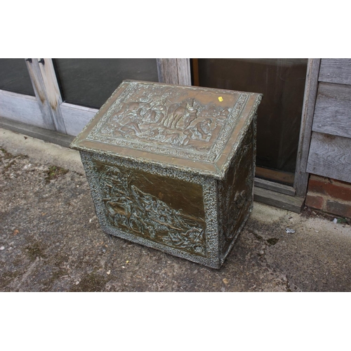 529 - An embossed brass log box with figure decoration, 22 1/2