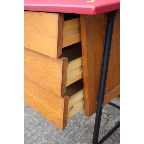 537 - A 1970s desk with leatherette top, fitted three drawers, on metal supports, 39