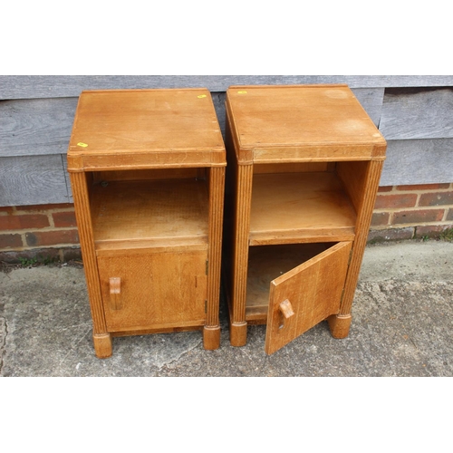 554 - A pair of 1930s light oak bedside cupboards, fitted shelf over one door, on shaped supports, 14