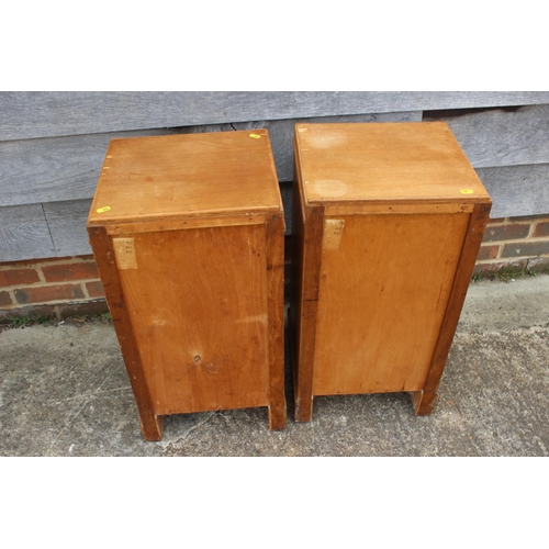 554 - A pair of 1930s light oak bedside cupboards, fitted shelf over one door, on shaped supports, 14