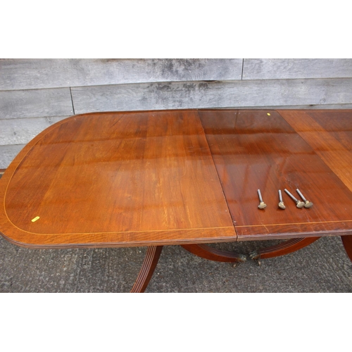 570 - A mahogany and banded double pedestal dining table with extra leaf, on tripod splay supports, 84