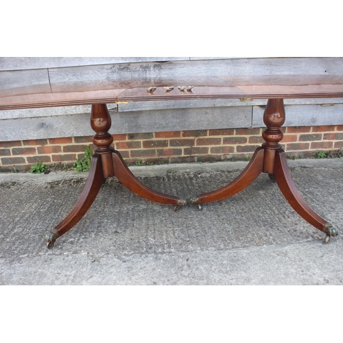 570 - A mahogany and banded double pedestal dining table with extra leaf, on tripod splay supports, 84