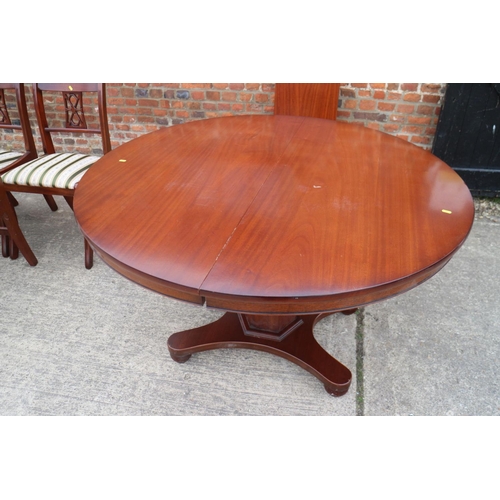 587 - A reproduction polished as mahogany circular  extending dining table with one extra leaf, on faceted... 