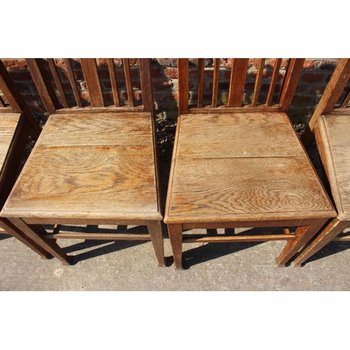 589 - A set of six early 20th century oak vertical rail back dining chairs with panel seats