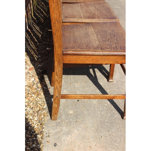 589 - A set of six early 20th century oak vertical rail back dining chairs with panel seats