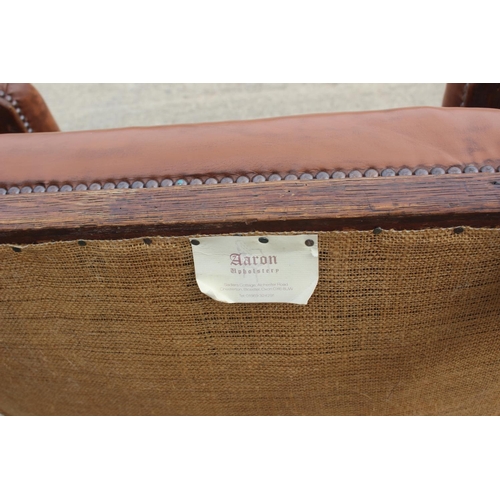 590 - A pair of Edwardian walnut and leatherette open armchairs, on turned supports