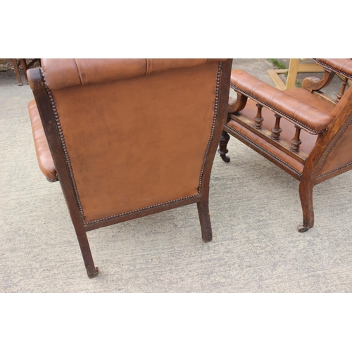 590 - A pair of Edwardian walnut and leatherette open armchairs, on turned supports