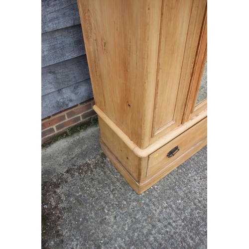 594 - A waxed pine wardrobe enclosed mirror door over one drawer, on block base, 42