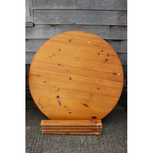 595 - A pine circular dining table, on shaped supports, 48