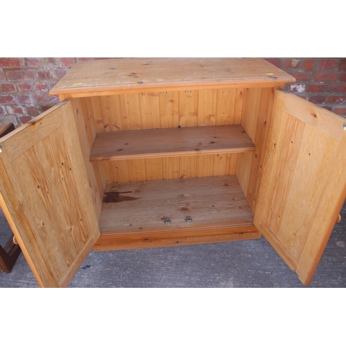 597 - A stripped pine side cabinet, fitted two doors, on block base, 29