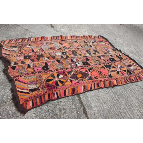 608 - A wool work wall hanging with geometric designs in shades of orange, pink, purple, red, grey and bla... 