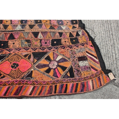 608 - A wool work wall hanging with geometric designs in shades of orange, pink, purple, red, grey and bla... 