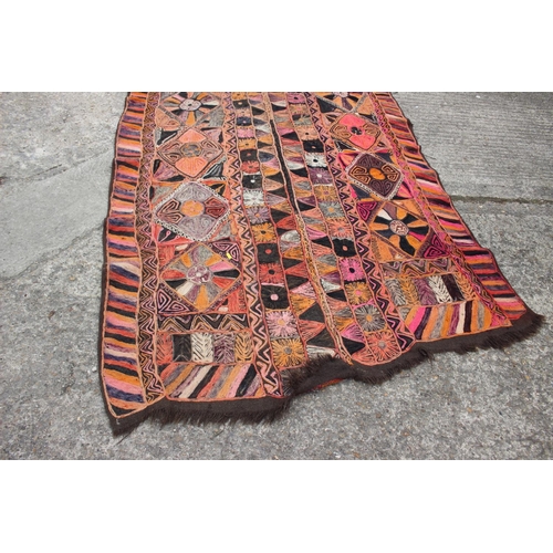 608 - A wool work wall hanging with geometric designs in shades of orange, pink, purple, red, grey and bla... 