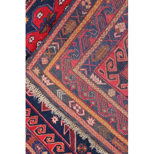 610 - A Middle Eastern wool rug with central medallion, geometric design and multi-bordered in shades of o... 