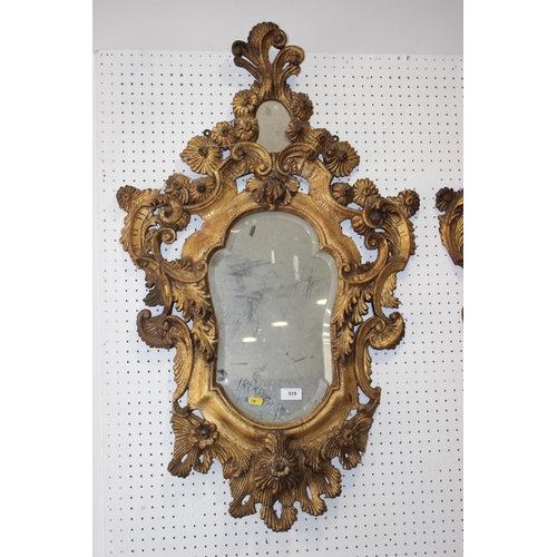 519 - A pair of late 19th century carved giltwood scrollwork wall mirrors with shaped plates, 38