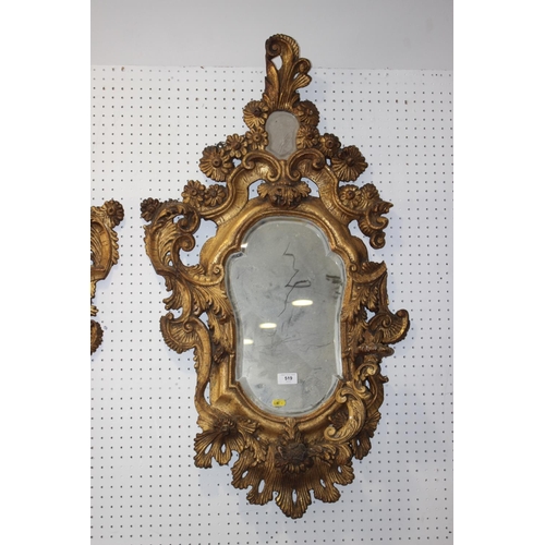 519 - A pair of late 19th century carved giltwood scrollwork wall mirrors with shaped plates, 38