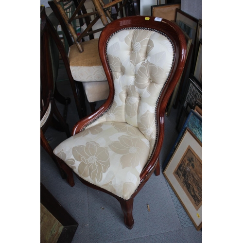 569 - A mahogany spoon back low chair, upholstered in a natural leaf patterned fabric, on cabriole support... 