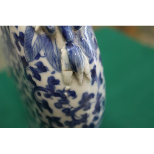 105 - A Chinese blue and white moon flask with relief lizard, leaf and scrolled decoration, 9 1/2